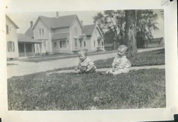 Two toddlers on a lawn, East 3rd Street houses behind, Albrecht family, dated 1929