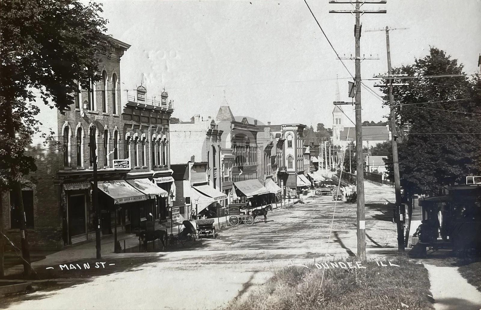 Fox River looking north near Main Street, Dundee, Illinois — two men fishing from a punt