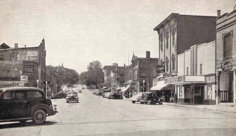 Main Street, Dundee, storefronts including a theater marquee reading "Dundee," late 1930s/1940s automobiles
